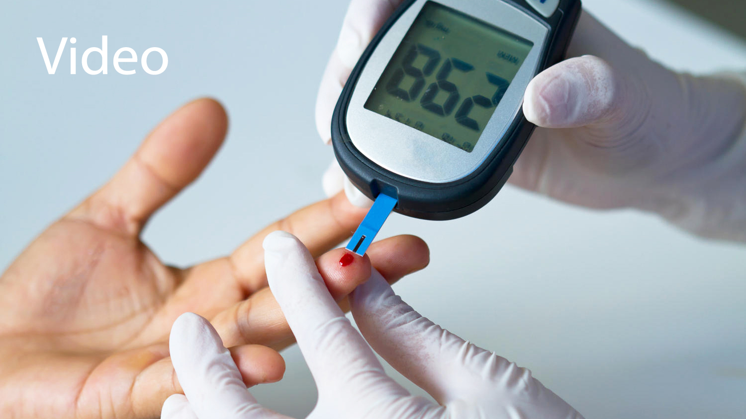 Hand of doctor and white glove show blood glucose meter, the blood sugar value is measured on a finger